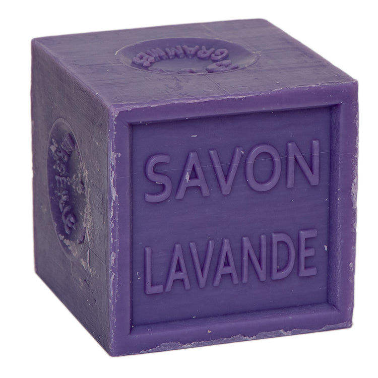 A purple cube of Marseille soap with the word 'Savon' and 'Lavande' inscribed on it, indicating its lavender fragrance.